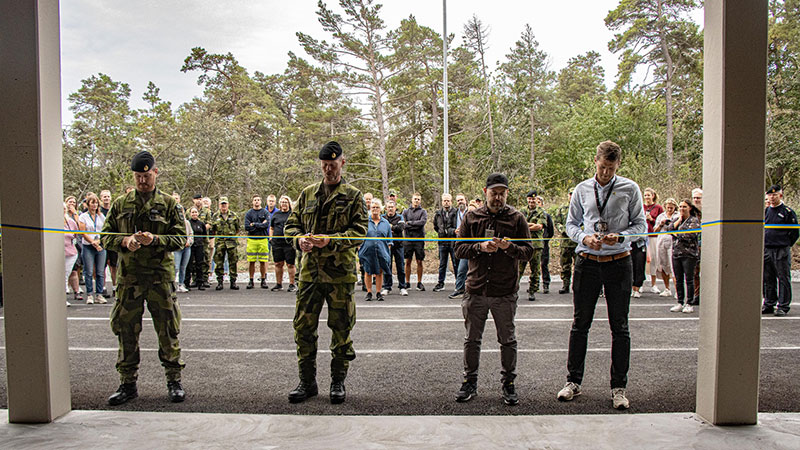 Två militärer och två civila personer klipper ett gult och blått band. I bakgrunden står många människor och ser på. 