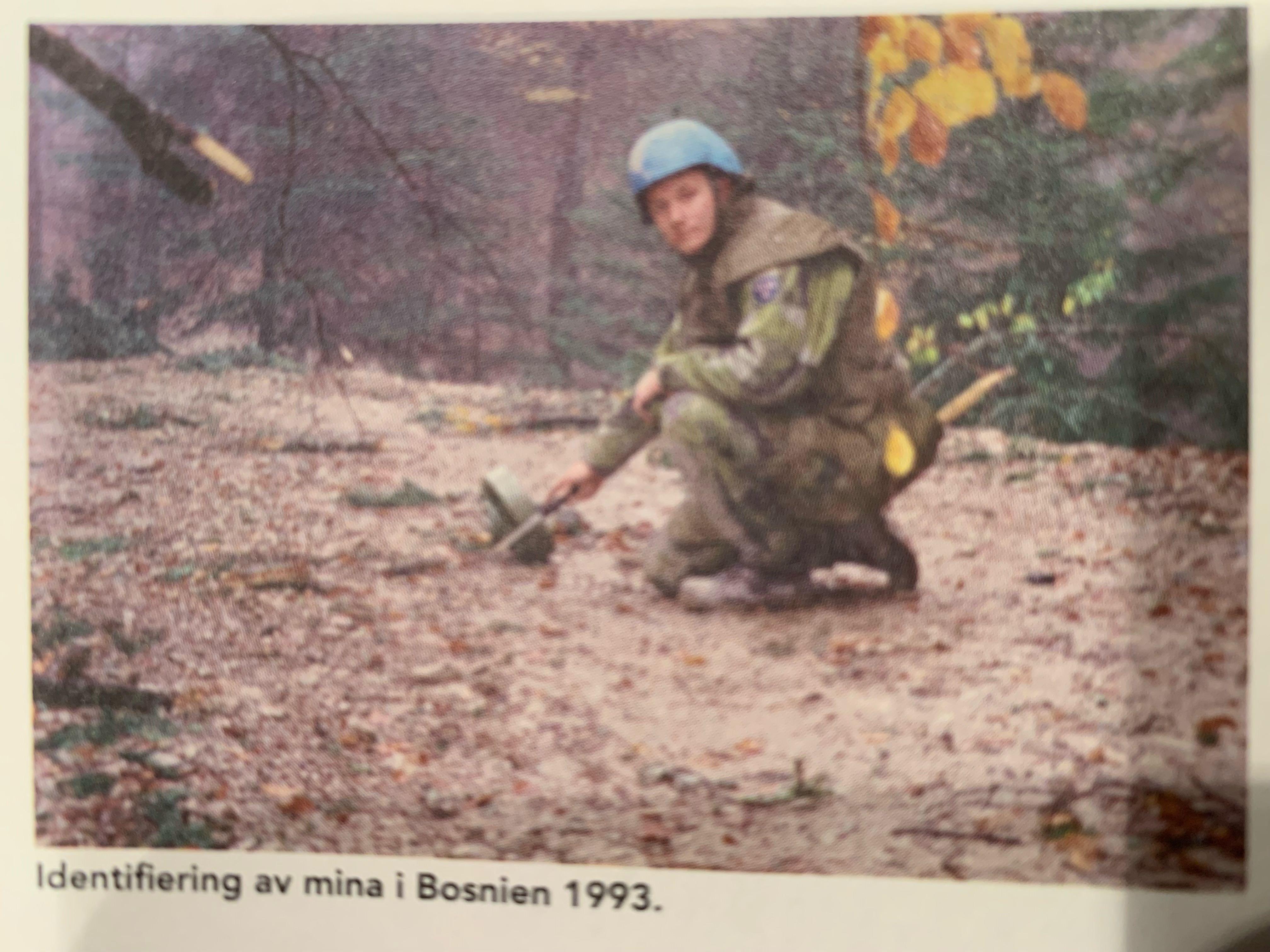 Tidningsurklipp på en FN-soldat som minröjer en platt yta.