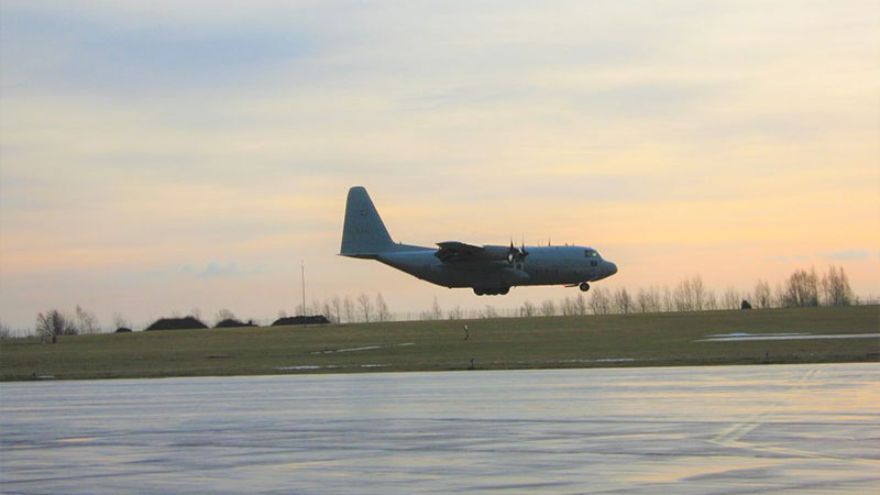 Militärflygplan på väg att landa, några meter kvar till rullbanan. 